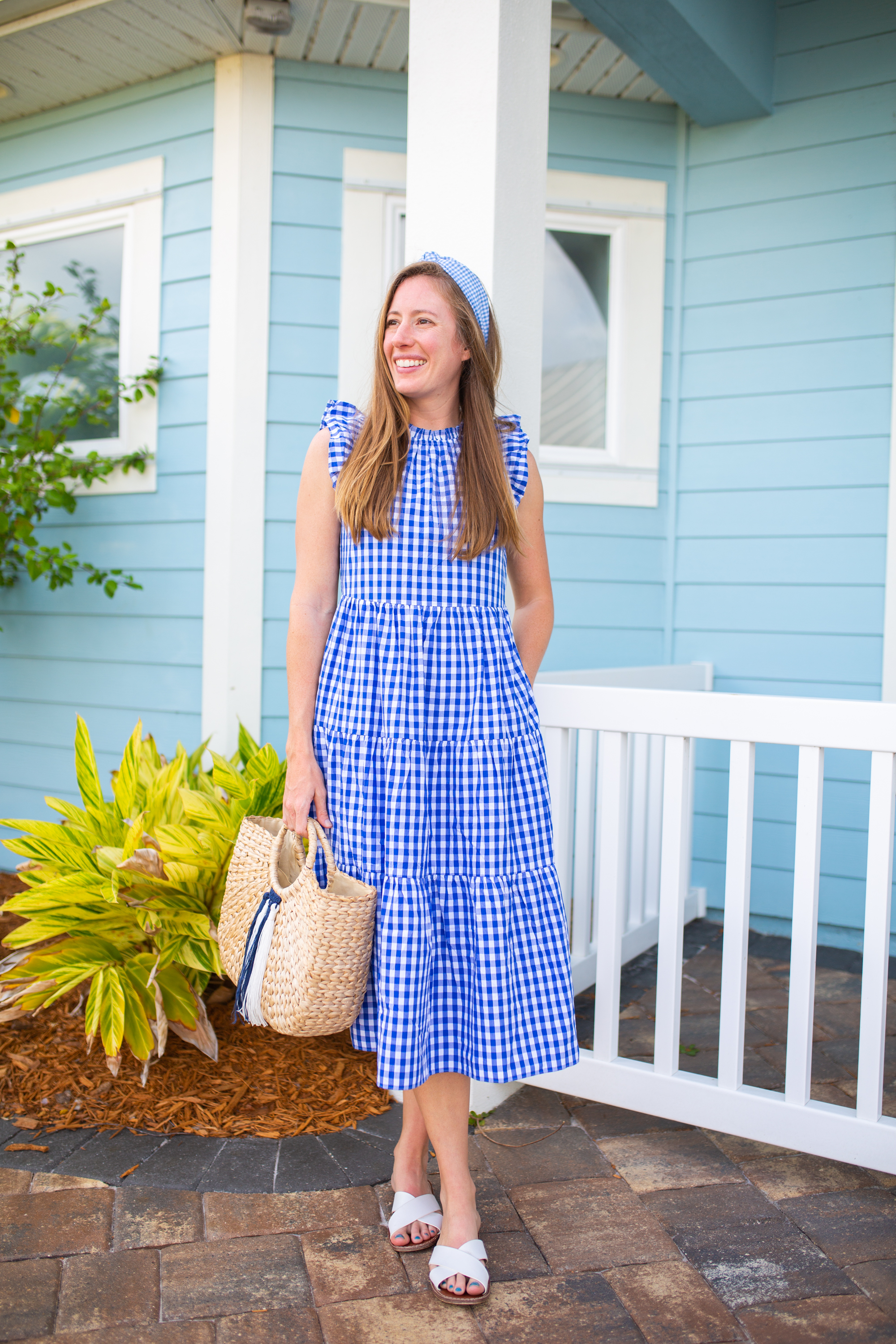 woman wearing a white sandals, holding a bag, and wearing J.Crew Gingham Tiered Dress 